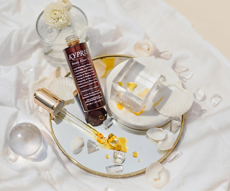 KYPRIS Beauty Elixir III with dropper, seashells, and crystals on a mirrored tray