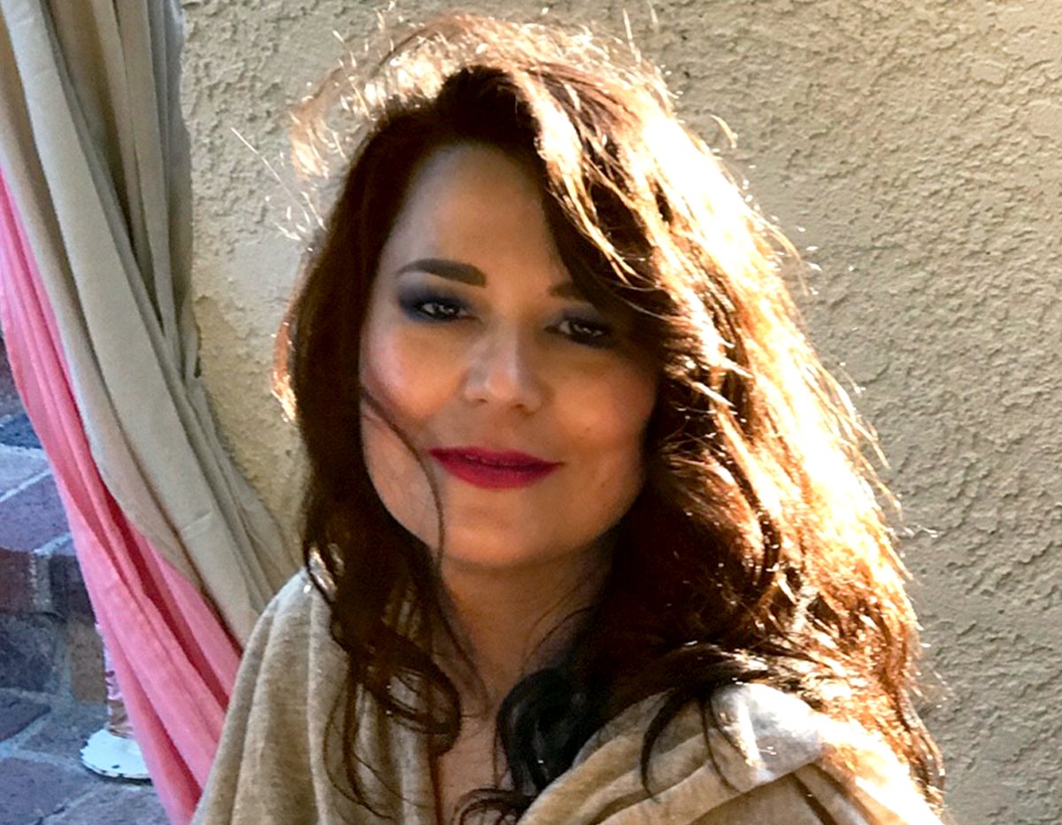 Woman with radiant skin and natural makeup, sunlit outdoor setting