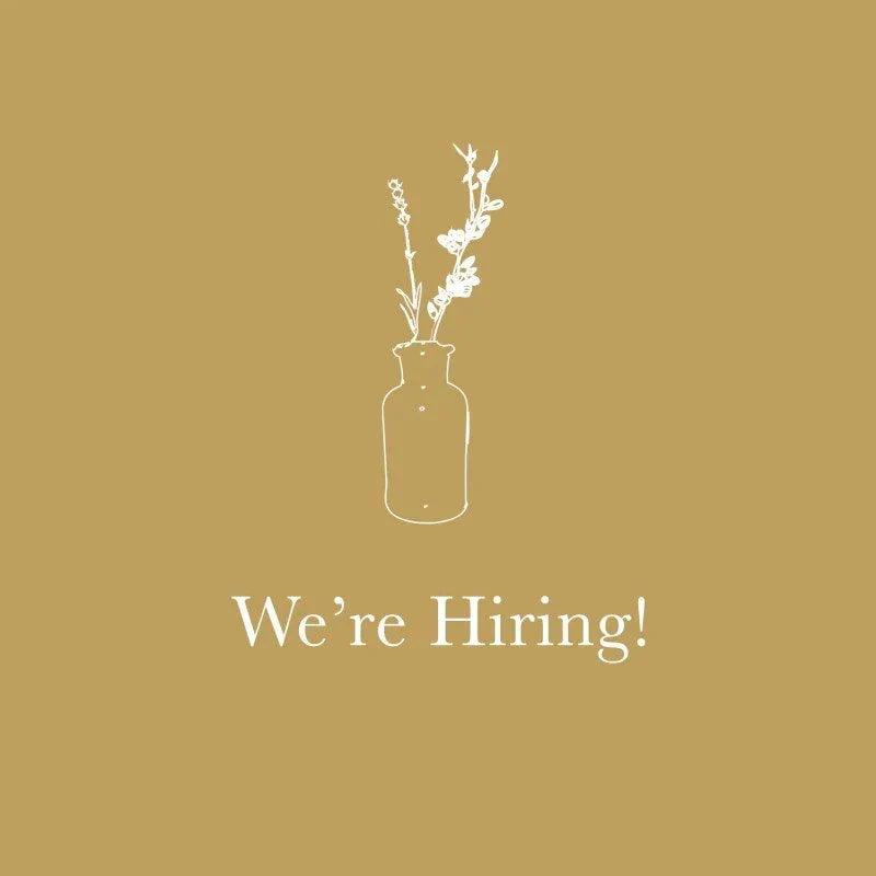 We're Hiring! with white floral illustration on gold background