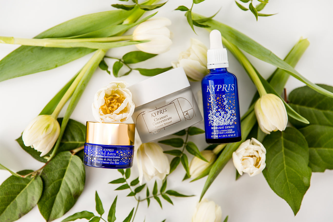 KYPRIS Ad Astra Nighttime Eye Cream, Cleanser Concentrate, and Moonlight Catalyst Serum with white tulips