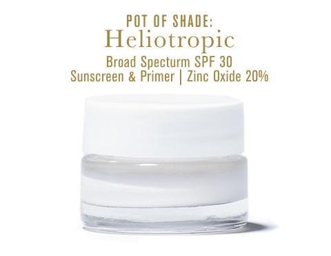 Pot of Shade: Heliotropic SPF 30, in clear glass jar with white lid, on white background.